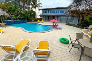 a swimming pool with chairs and a red umbrella at Sugar Sands C in St. Pete Beach