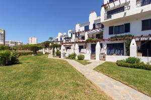 un gran edificio blanco con un patio de césped al lado en Charming Apartment with Sea Views en Mijas Costa