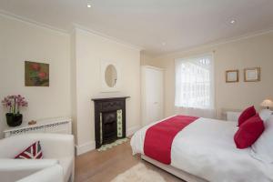 Dormitorio blanco con cama y chimenea en Lux City Centre Property, Slps 8 en Bath