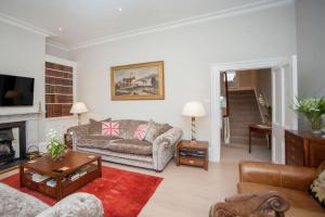 a living room with a couch and a fireplace at Blenheim House - Luxury City Centre Georgian Townhouse for 8 in Bath
