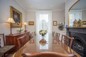 a living room with chairs and a fireplace and a table at Blenheim House - Luxury City Centre Georgian Townhouse for 8 in Bath