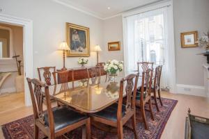 a dining room with a glass table and chairs at Lux City Centre Property, Slps 8 in Bath