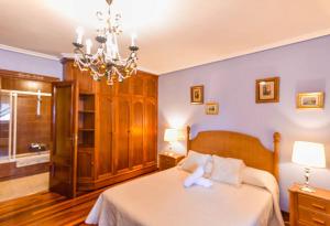 a bedroom with a bed and a chandelier at Vistas increíbles! a 3 minutos de la playa con Wifi in Santander
