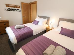 Habitación de hotel con 2 camas con sábanas moradas y blancas en New Elm Tree Farm, en Buxton