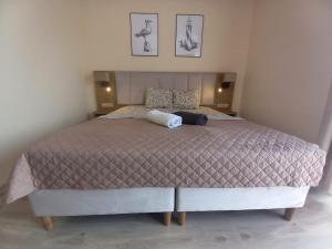 1 dormitorio con 1 cama grande y 2 cuadros en la pared en Villa Lima en Ustka