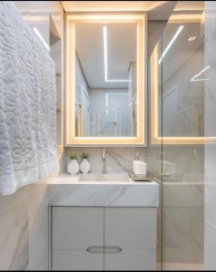 a bathroom with a sink and a mirror at Flat encantador Slaviero Complexo Heron Marinho in Campina Grande