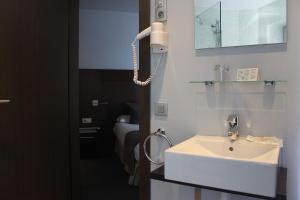 a bathroom with a white sink and a mirror at Hotel Madanis Liceo in Hospitalet de Llobregat