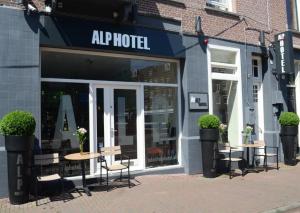 een winkel met tafels en stoelen voor een gebouw bij Alp Hotel in Amsterdam