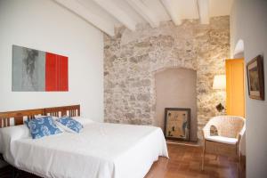 een slaapkamer met een wit bed en een stenen muur bij Let's Holidays NICE HOUSE CLOSE TO THE CASTLE in Tossa de Mar
