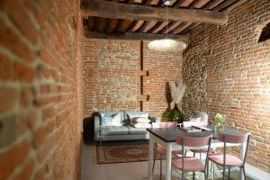 Cette chambre en briques dispose d'un canapé, d'une table et de chaises. dans l'établissement La casa dei Mimmi, à Città della Pieve
