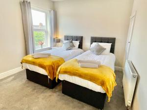 two twin beds in a room with a window at The Balmoral close to the racecourse in York