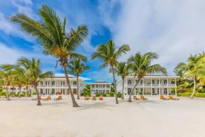 um grande edifício branco com palmeiras na praia em Tara Del Sol Resort em San Pedro