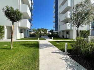 uma passagem em frente a um edifício de apartamentos em Blu Homes Apartments EfStyle Hotel em Lido di Jesolo