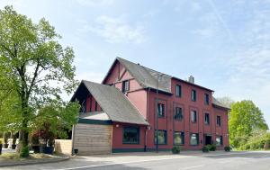 a large red building with a black roof at Hôtel Restaurant Lamy in Troisvierges