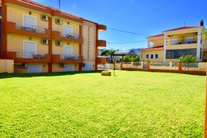 a large green yard in front of a building at Pfaffenhofen in Nea Vrasna