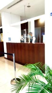 a lobby with a reception desk with two people in the background at Skyna Hotel Luanda in Luanda