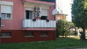 um edifício cor-de-rosa com uma varanda e uma ventoinha em Appartamento Intero Bilocale Totalmente Arredato A Padova em Pádua