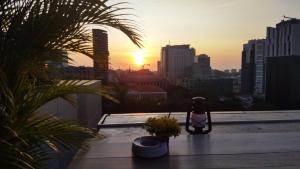 een uitzicht op de zonsondergang vanaf een dak met een standbeeld bij Skyna Hotel Luanda in Luanda