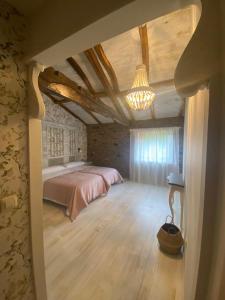 1 dormitorio con cama y lámpara de araña en Casa Meiga, en Arzúa