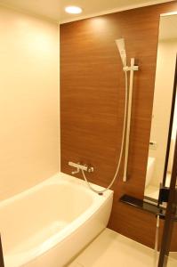 y baño con bañera y ducha. en Hakuba Grand Apartments, en Hakuba