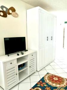 a living room with a flat screen tv on a white cabinet at Coastal Cozy - Ocean View at Symphony Beach Club in Ormond Beach