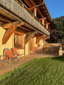 a porch of a house with chairs and a deck at La Ferme des Georgières -Pour votre confort, le séjour inclut les draps, les serviettes de bain et le ménage- in Notre-Dame-de-Bellecombe