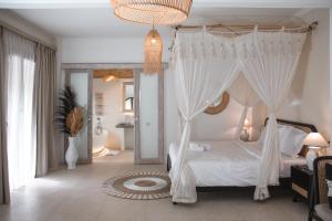 a bedroom with a canopy bed with white drapes at Hot Stone Club Ubud in Ubud