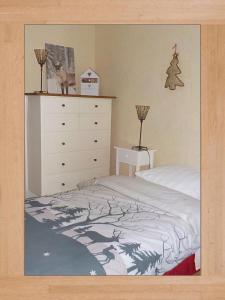 ein Schlafzimmer mit einem Bett und einer Kommode in der Unterkunft LES LILAS in Sainte-Marie-aux-Mines
