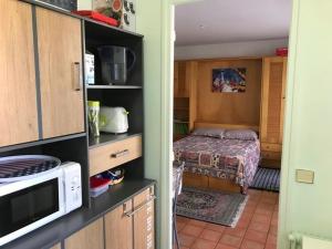 a small bedroom with a bed and a microwave at Studio Saint-Jean-de-Luz, 1 pièce, 2 personnes - FR-1-4-522 in Saint-Jean-de-Luz