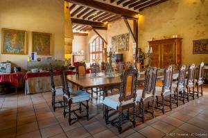 jadalnia z długim stołem i krzesłami w obiekcie Le vieux château de Hommes w mieście Hommes