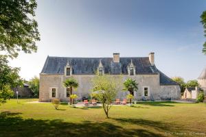 una gran casa de piedra con techo negro en Le vieux château de Hommes en Hommes