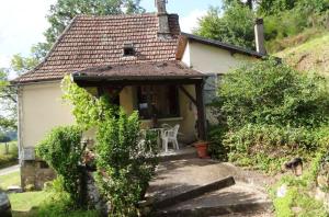 ein kleines Haus mit einem Stuhl davor in der Unterkunft Maison de 3 chambres avec jardin clos a Teyssieu in Teyssieu