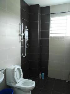 a bathroom with a shower and a toilet and a sink at Fong's Ipoh SImpang Pulai Homestay in Ipoh