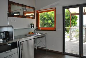 a kitchen with a sink and a sliding glass door at Villa Lodge 4 Epices in Gustavia