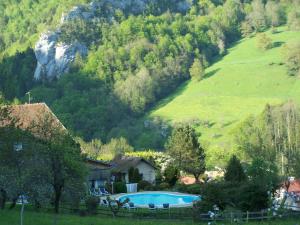 a house and a swimming pool in a mountain at Hôtel Restaurant Taillard in Goumois