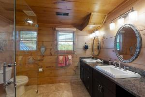 a bathroom with two sinks and a toilet and mirrors at Elk Lodge in Tazewell +34 photos