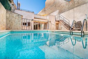 a swimming pool with blue water in a building at Villa Caldentey in Ariany