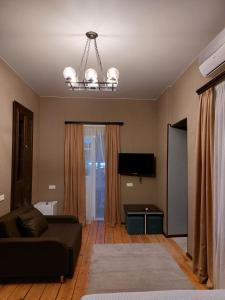 ein Wohnzimmer mit einem Sofa und einem Kronleuchter in der Unterkunft Resting Place in Tbilisi City