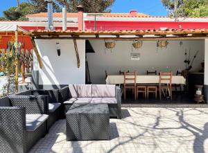 un patio con sofás, mesa y sillas en Villas Pedroso: nature, mountains and the ocean, en Cascais