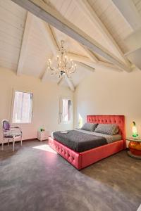 una grande camera da letto con un letto rosso e un lampadario a braccio di Simone Cenedese Murano Apartments - Cristallo a Murano