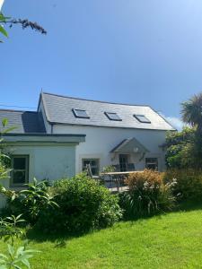 a white house with a roof and a yard at Ancaire Cottage Kilbronogue. Schull in Schull +7 photos