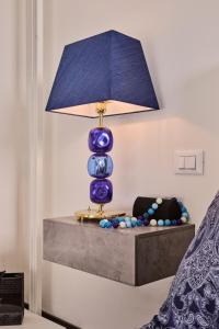 un jarrón azul sentado en una mesa con una lámpara en Simone Cenedese Murano Apartments - Cristallo, en Murano