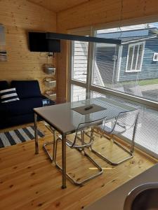 a glass table and two chairs in a living room at Pajūrio brizas in Šventoji