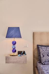 una lampada blu seduta su un tavolo accanto a un letto di Simone Cenedese Murano Apartments - Cristallo a Murano