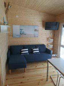 a living room with a blue couch and a television at Pajūrio brizas in Šventoji