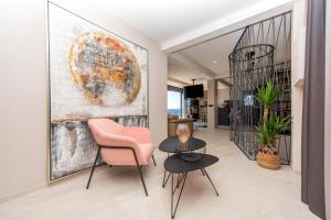 a living room with a pink chair and a table at Vila Aurelia 2 in Makarska