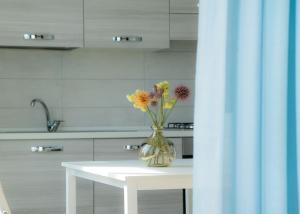 a vase with flowers sitting on a table in a kitchen at I SUONI DEL MARE in Porto San Giorgio +219 photos