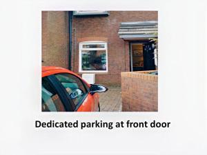 a red car parked in front of a brick house at City Centre - Parking - Great Location - 4 Beds in Belfast