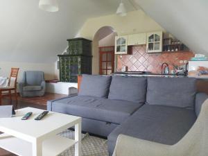 un soggiorno con un divano blu e una cucina di Berek Vendégház Fonyód a Fonyód
