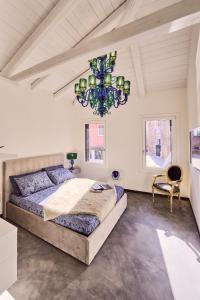 a bedroom with a large bed and a chandelier at Simone Cenedese Murano Apartments - Cristallo in Murano